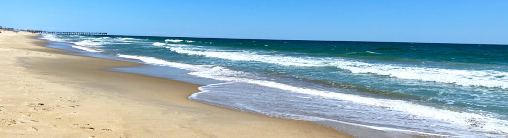 Sandy beach with blue sky and waves